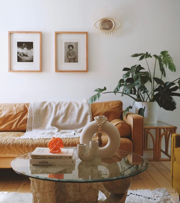 Living room with a cognac leather sofa, a grey wool throw blanket, and a big palm plant