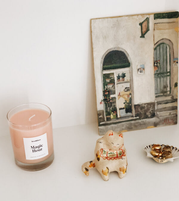 Magic Hour candle on a shelf with a lucky cat