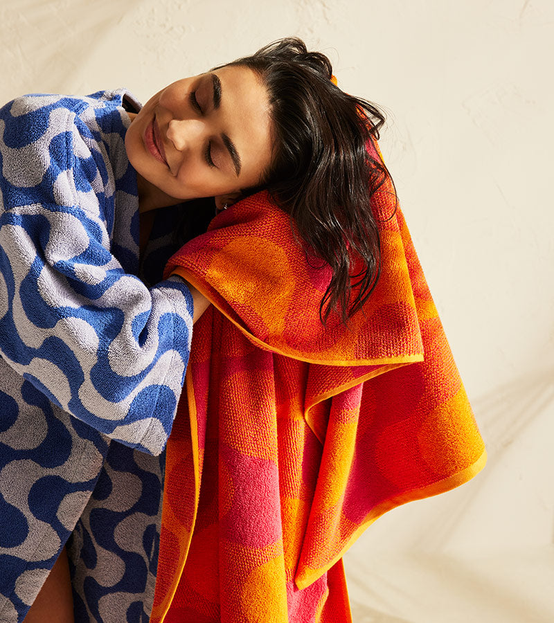Women wearing wave robe drying her hair with a wave length print towel 